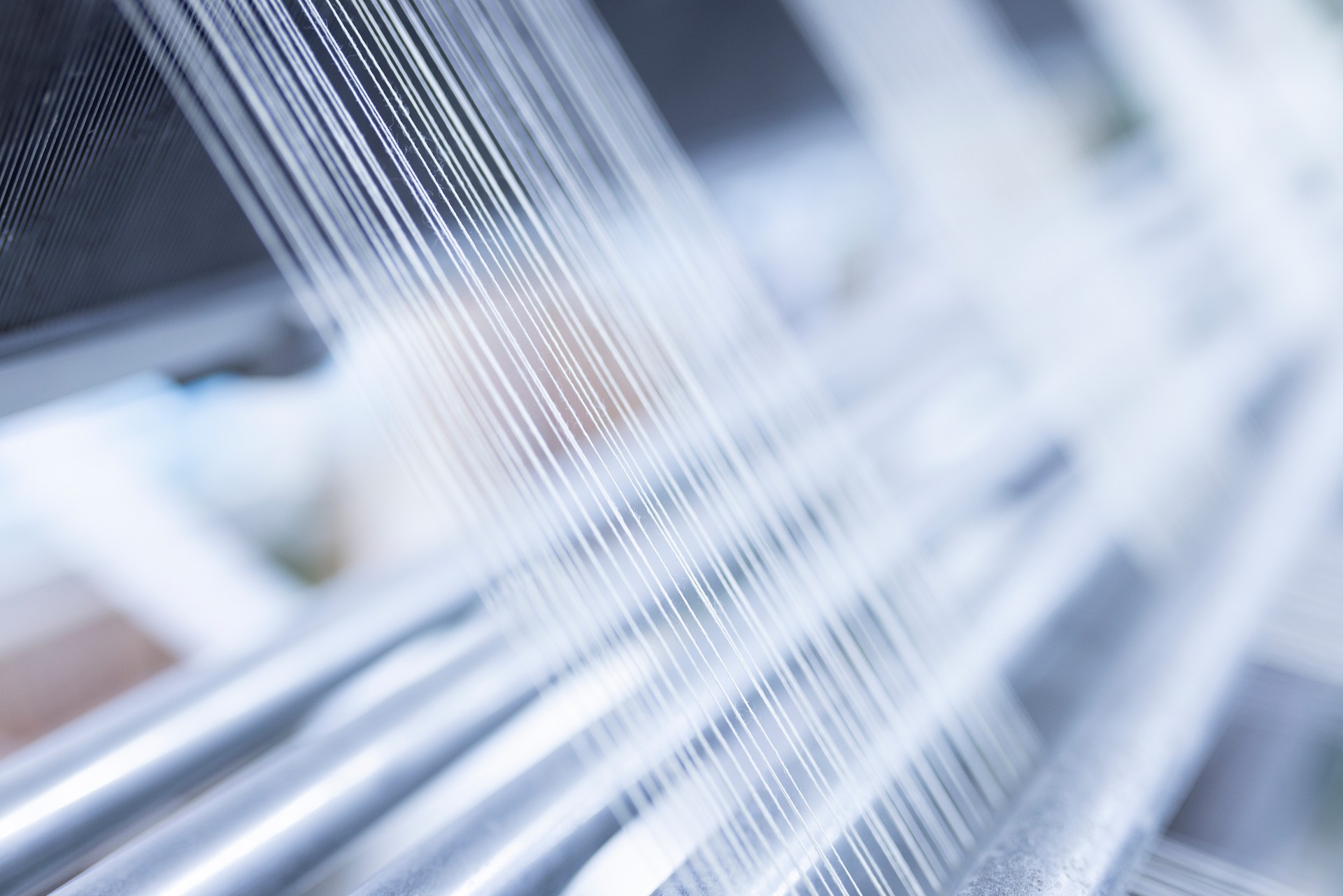 Close up macro detail of Yarn thread lines running in the weaving loom machine. Yarn thread lines background. Yarn thread lines texture. Textured fabric background